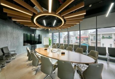 Large boardroom with an oval wooden table and a striking sunburst ceiling light fixture.