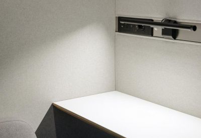 Interior view of a private soundproof acoustic pod with a built-in desk and lighting.