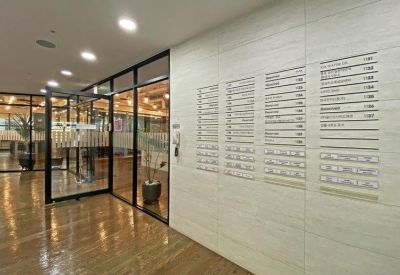 Wall-mounted tenant directory next to a glass office entrance.