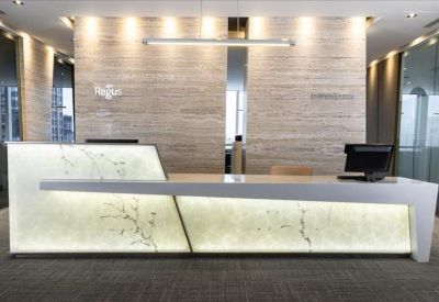 Sophisticated reception area featuring a backlit marble desk and warm wood-paneled walls.