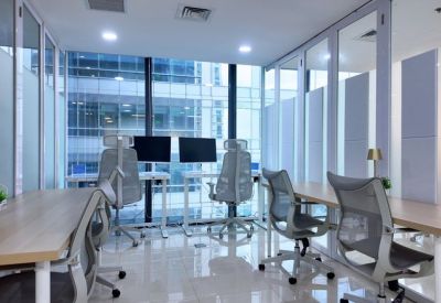 Bright workspace with multiple desks separated by glass partitions.