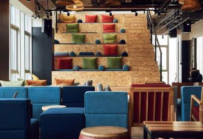 Lounge area with blue modular seating and tiered wooden bleachers in the background.
