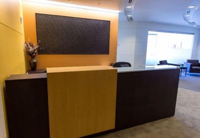 Modern reception desk with wood panelling and a dark feature wall.