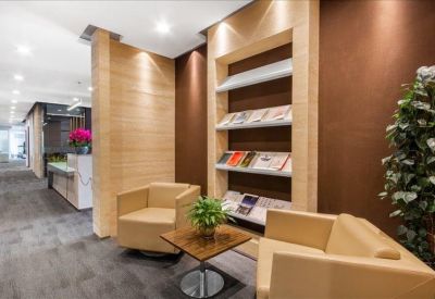 Lounge area with tan armchairs and a built-in magazine rack.