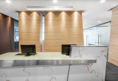 Sleek reception desk with wood paneling and marble-style front.