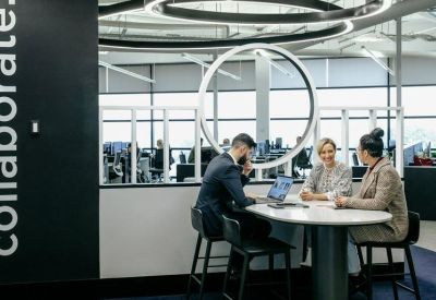 Coworking space with circular light fixtures and people collaborating at a high table.