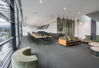 Spacious open plan office with lounge seating and a long timber desk.