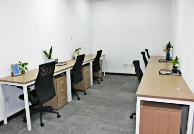 Bright office suite with two long desks, ergonomic chairs, and integrated storage drawers.