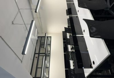 Professional workspace featuring rows of white desks and sleek black privacy dividers.