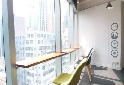 Coworking space along a window wall with bright yellow and black chairs.