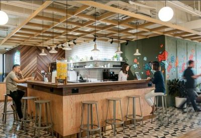 Stylish café area with a wooden bar counter, geometric tile flooring, and hanging pendant lights.