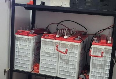 Storage area containing a rack of industrial backup batteries and power equipment.