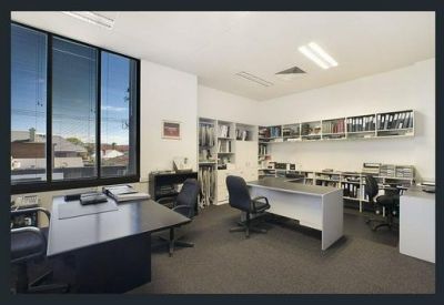 Spacious office suite featuring multiple workstations and large windows for natural light.