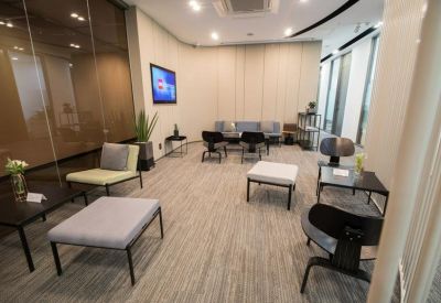 Contemporary lounge area with varied seating and a wall-mounted television.