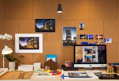 Close-up of a workstation with a cork pinboard and decorative items.