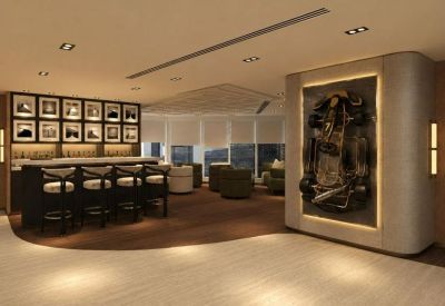 Spacious lounge at Tower One, Lippo Centre featuring a bar with stool seating and a racing-themed feature wall.