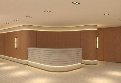 Curved wood-paneled reception desk with warm integrated accent lighting.