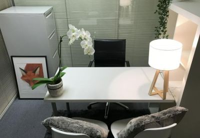 Bright private office suite with desk lamp, orchid, and filing cabinet.