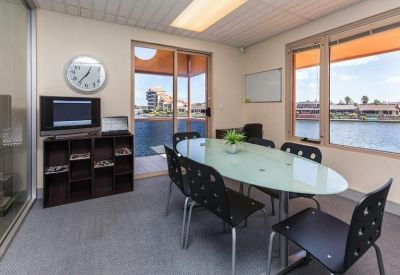Modern meeting room with an oval glass table and views of the water.