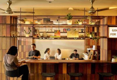 Stylish café-style breakout area with a wooden bar counter and decorative shelving.