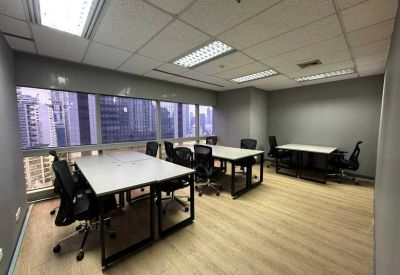 Bright open-plan office with multiple workstations and large windows overlooking the city.