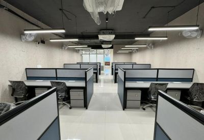 Modern open-plan workspace with multiple rows of cubicles and grey office chairs.