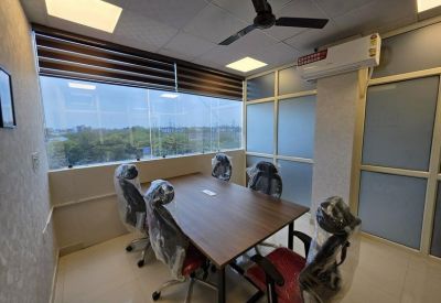 Four-person meeting room with a wooden table and a window overlooking greenery.