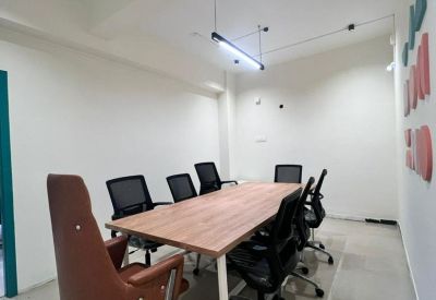 Professional conference space with a large wooden desk and sleek brown accent chairs.