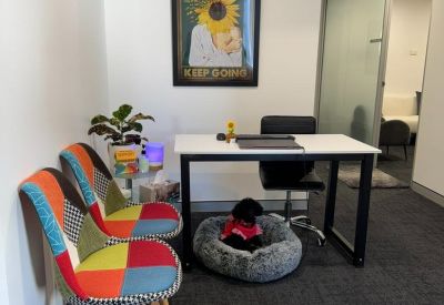 Bright reception space featuring colorful upholstered chairs and framed sunflower artwork.