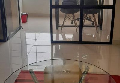 Glass-walled office entrance featuring a transparent table and a motivational sign on the wall.