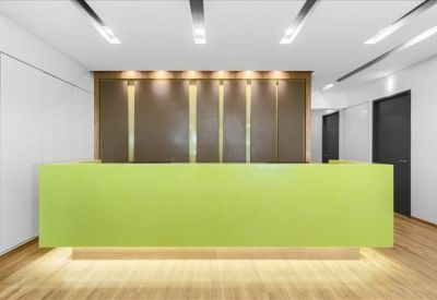 Modern minimalist reception desk in bright lime green with wood flooring.