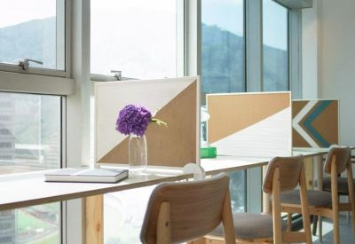 Window-facing workstations with wooden chairs and mountain views through floor-to-ceiling glass.