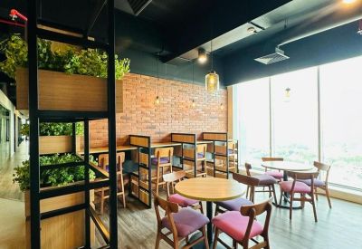 Communal seating area with greenery and large windows.