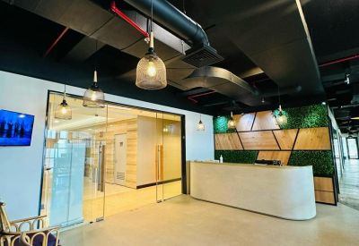 Reception area with modern desk and green wall accents.