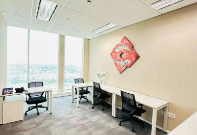 Office area with multiple desks and bright window views.