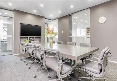 Modern boardroom with a large light wood table and wall-mounted television.