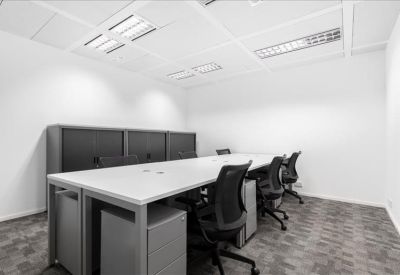Four-person internal private office with white desks and black ergonomic chairs.