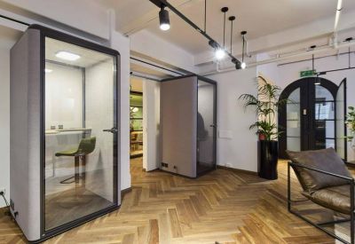 Contemporary office lounge with herringbone wood floors and individual soundproof privacy booths.