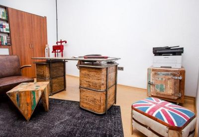Private office with a rustic wooden desk and vintage leather armchair.