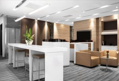 Spacious communal lounge with high tables, stools, and comfortable armchairs.