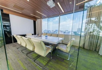 Professional meeting room with a long white table and floor-to-ceiling glass walls.