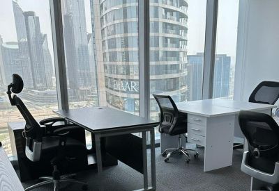 Bright office suite with two white desks and ergonomic chairs overlooking the city skyline.