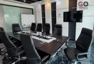 Professional boardroom with a large dark wood table, black leather chairs, and a whiteboard.