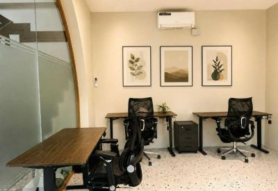 Private office setup with three desks, ergonomic chairs, and botanical wall art.