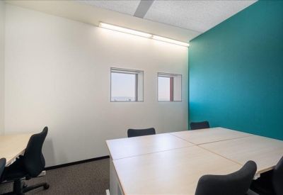 Private office featuring a bright teal accent wall and white desks.
