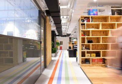 Modern corridor featuring a colorful striped floor and light wood shelving unit.