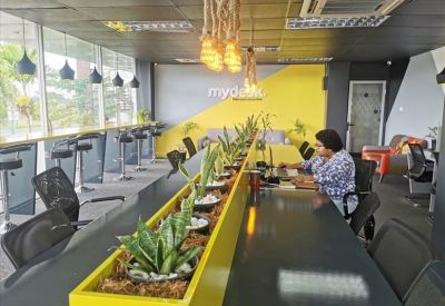 Bright open-plan office with green ergonomic chairs and wooden floors.