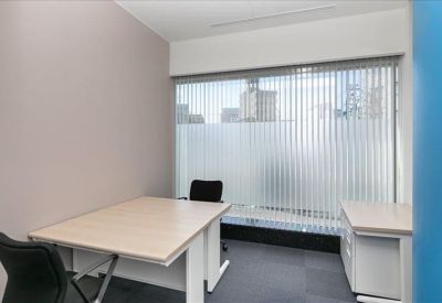 Private office suite featuring a light wood desk and a vertical-blind window.