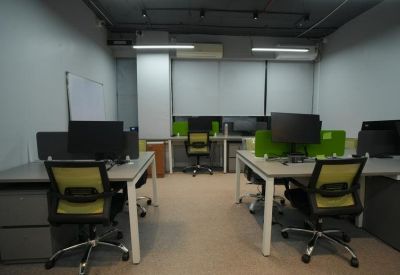 Internal coworking area with ergonomic mesh chairs and bright white overhead lighting.