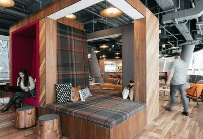 Modern breakout area featuring wooden booth seating and plaid upholstery.